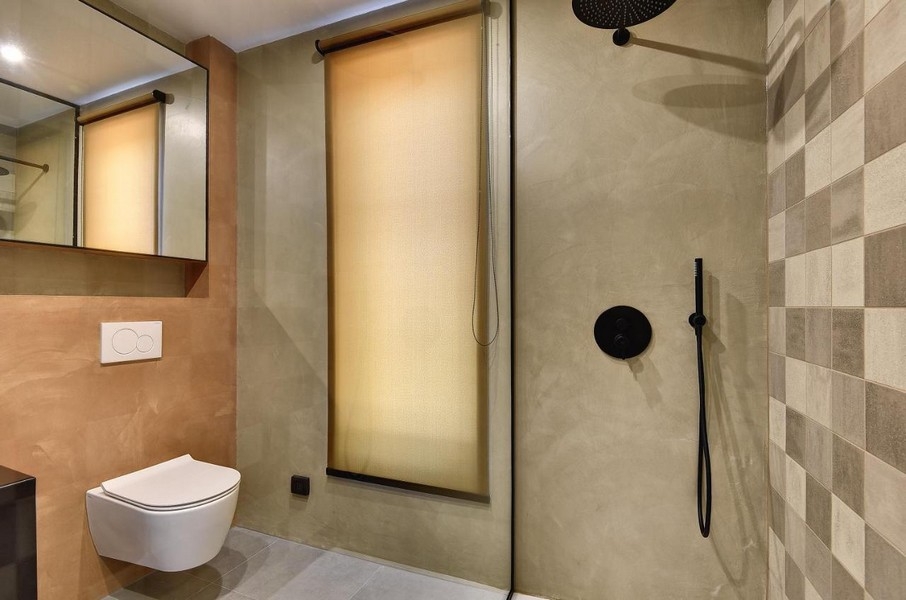 Badrum med dusch i golvnivå och beige kakel