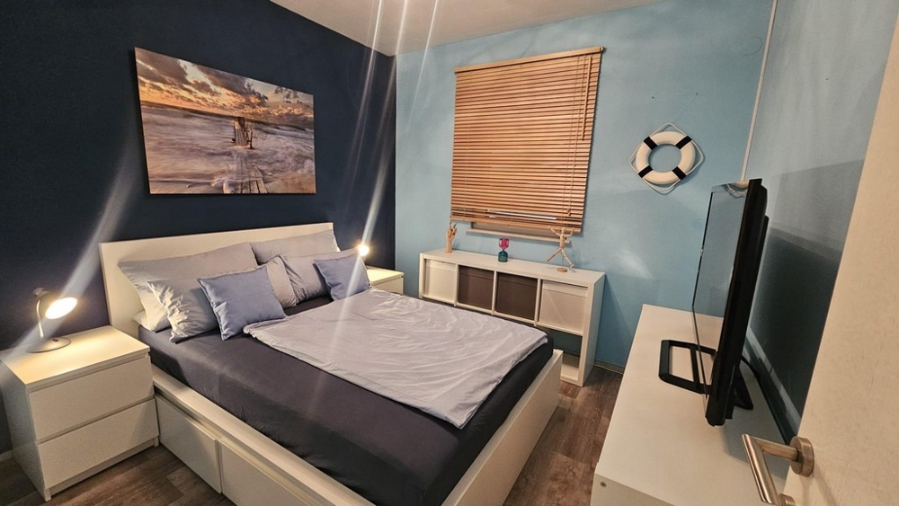 Sovrum med dubbelsäng och maritim inredning