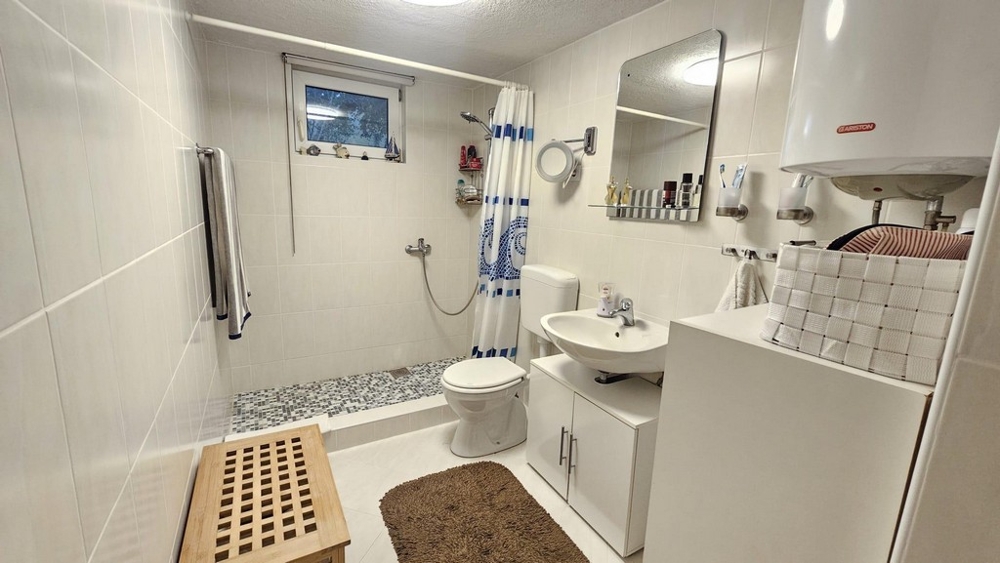 Badrum med dusch, handfat och toalett