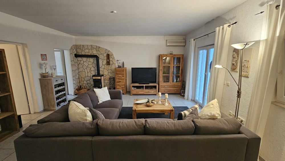 Vardagsrum med soffa, TV och öppen spis