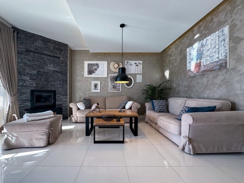 Vardagsrum med öppen spis, soffor och stilren design