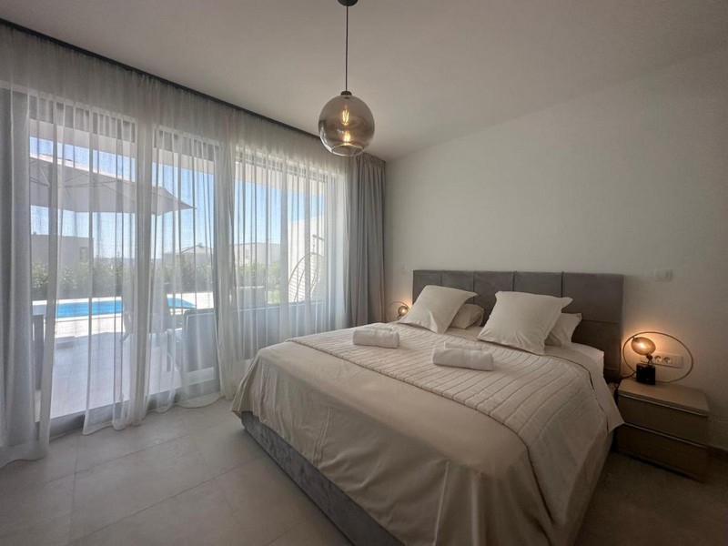 Sovrum med modern design och utsikt över poolen