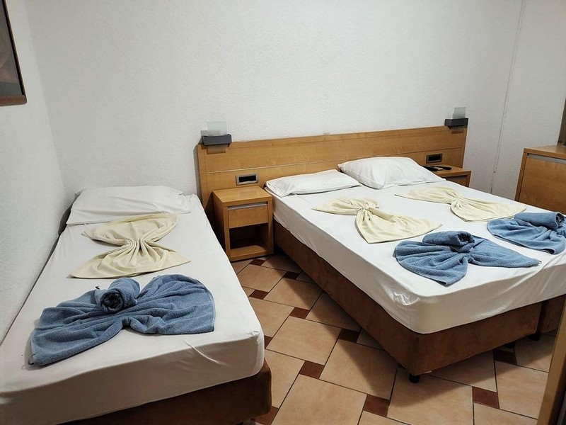 Rum med dubbelsäng och enkelsäng i gästhuset