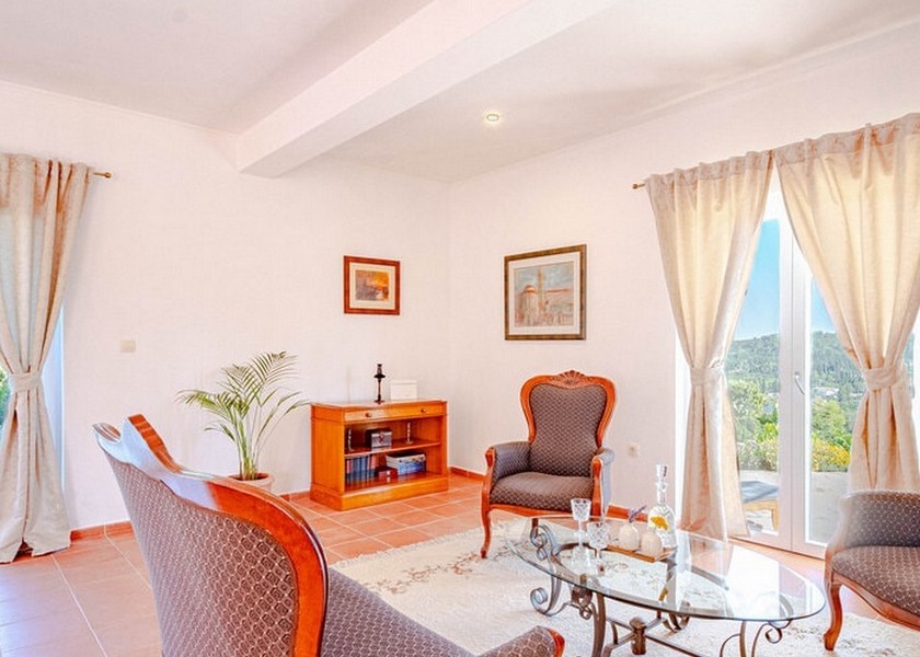 Vardagsrum med klassiska möbler och utsikt över trädgården