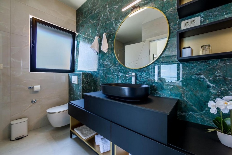 Badrum med svart handfat och elegant inredning