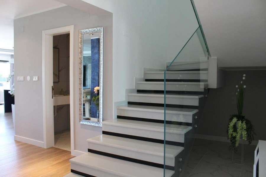 Trappa med glasräcken och ljus hall