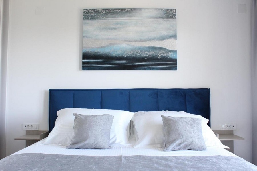 Dubbelsäng i modernt sovrum med dekorativ väggmålning