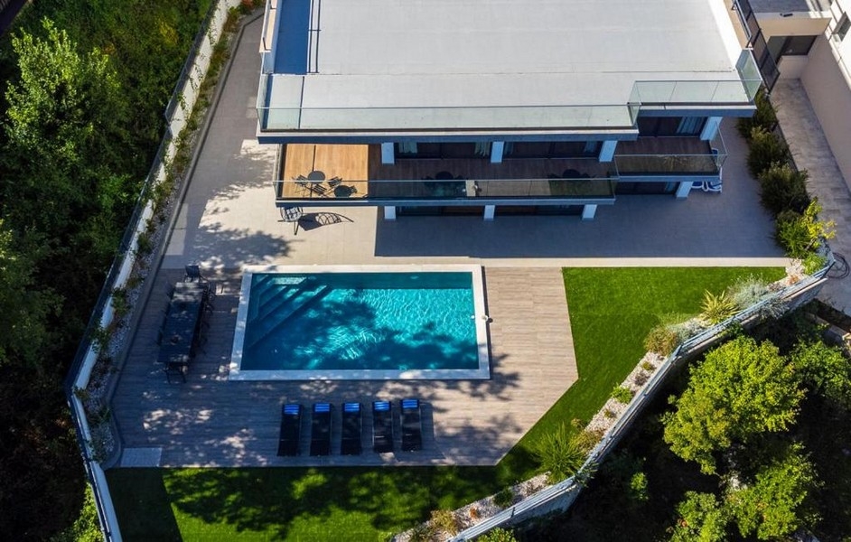 Flygfoto över villa med stor pool och trädgård