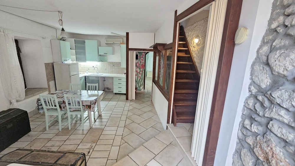 Vardagsrum med kök och trätrappa