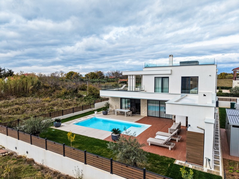 Flygfoto över villa med trädgård och pool