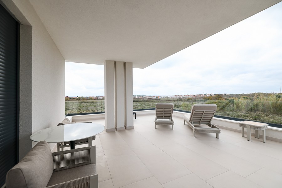 Övertäckt terrass på övervåningen med utsikt