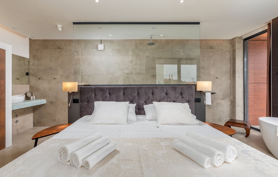 Vitt sovrum med glasbadrum av Villa H3764.