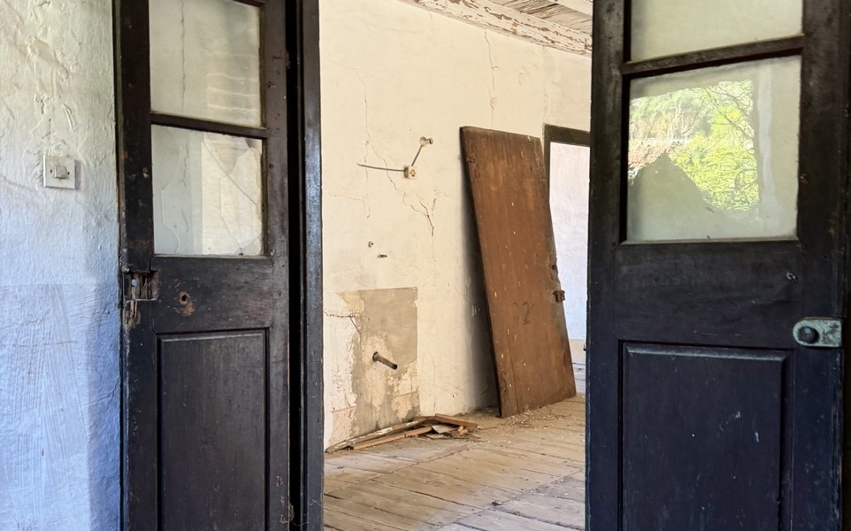 Inredning med öppna dörrar och synligt behov av renovering
