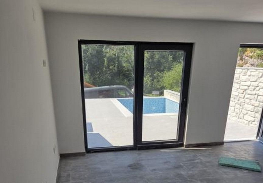Utsikt från insidan till terrassen och poolen