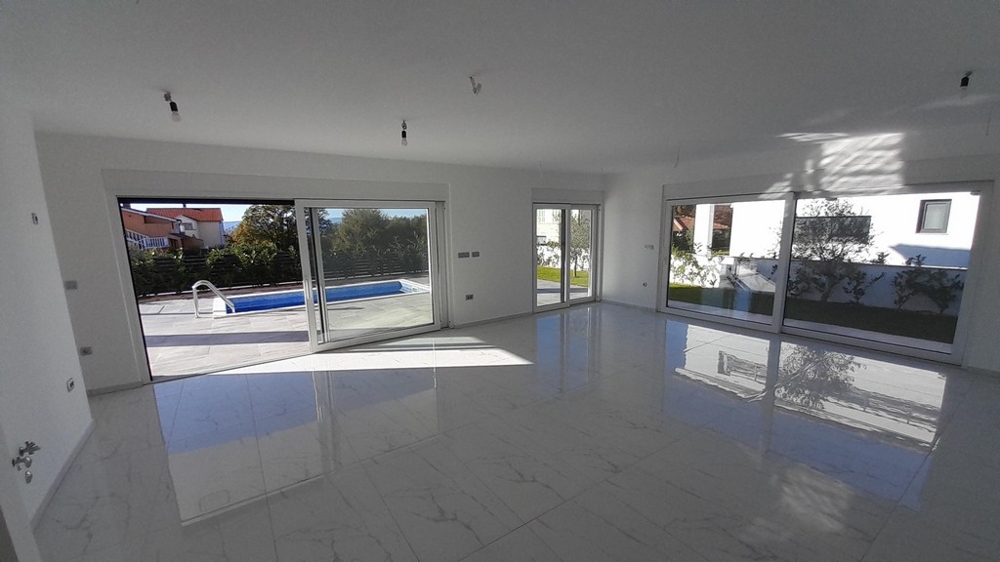 Ljust vardagsrum med tillgång till poolområdet