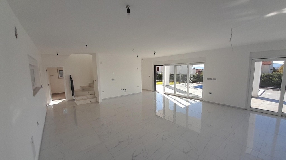 Rymligt vardagsrum med trappa till övervåningen i Villa H3772