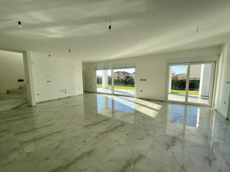 Ljust vardagsrum med fönster från golv till tak