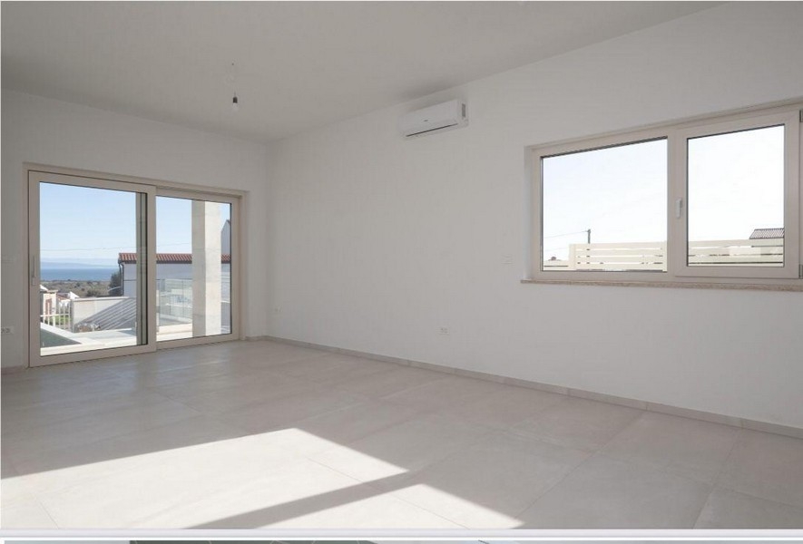 Ljust vardagsrum med stora fönsterpartier