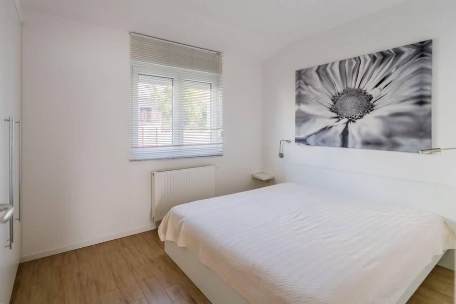 Sovrum med dubbelsäng och stor väggmålning