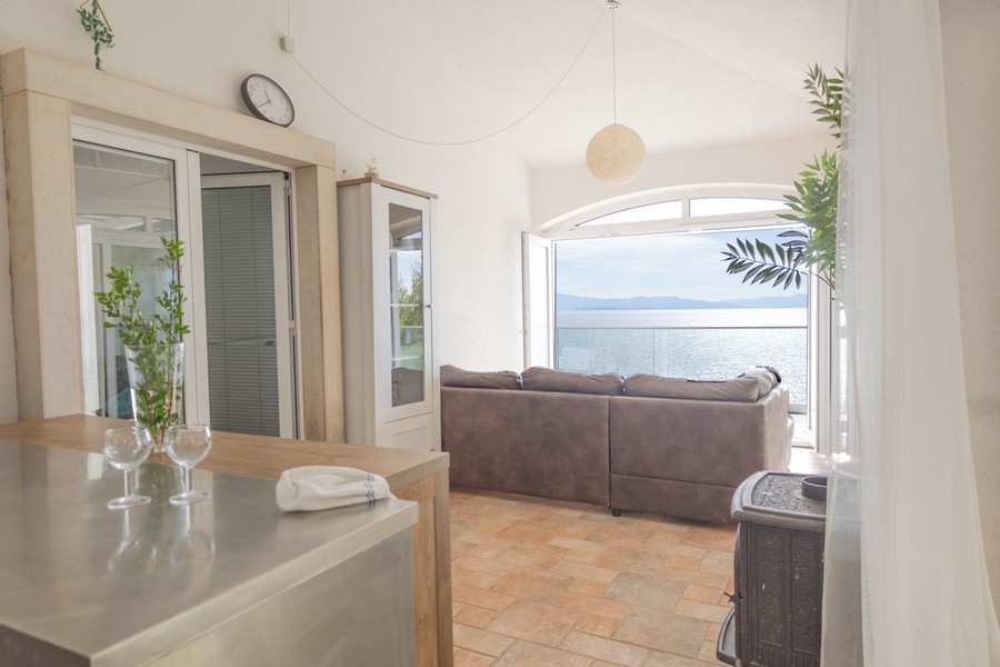 Vardagsrum med stort fönster och panoramautsikt över havet