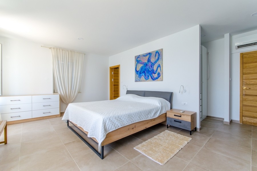 Sovrum med dubbelsäng och byrå