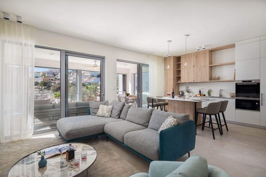 Öppet vardagsrum med kök och stort fönsterfront