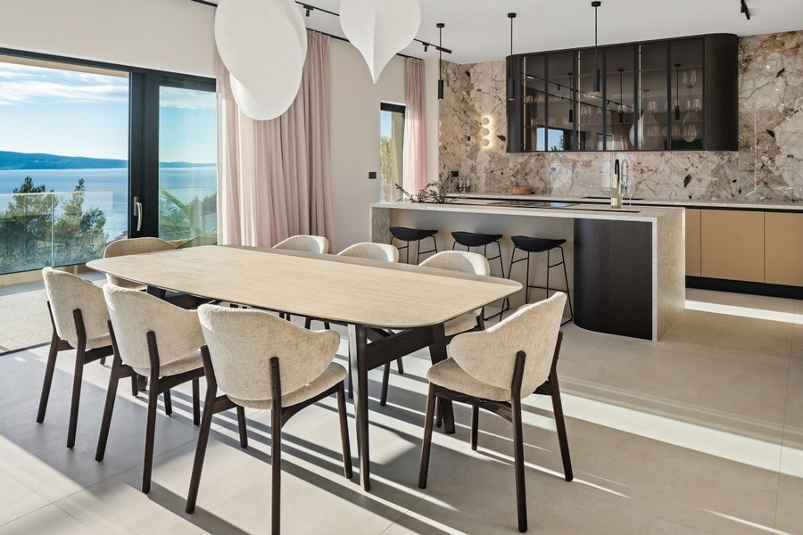 Designkök med bakvägg i natursten och bardisk