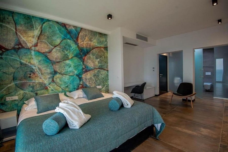 Sovrum med dubbelsäng, väggdesign och badrum med eget badrum