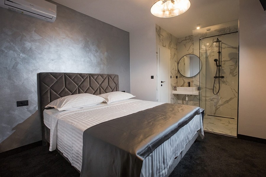 Sovrum med dubbelsäng och öppet badrum en-suite