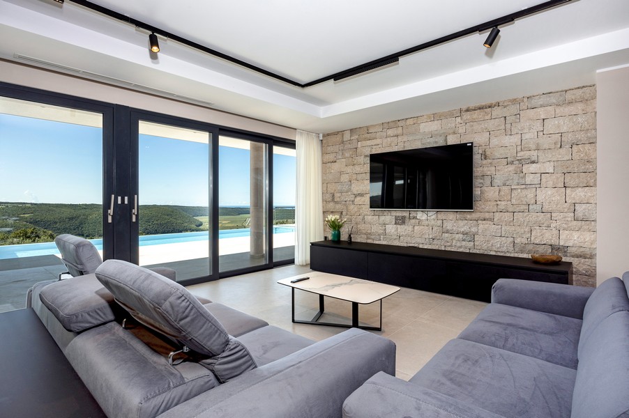 Vardagsrum med panoramafönster och utsikt över grönskan