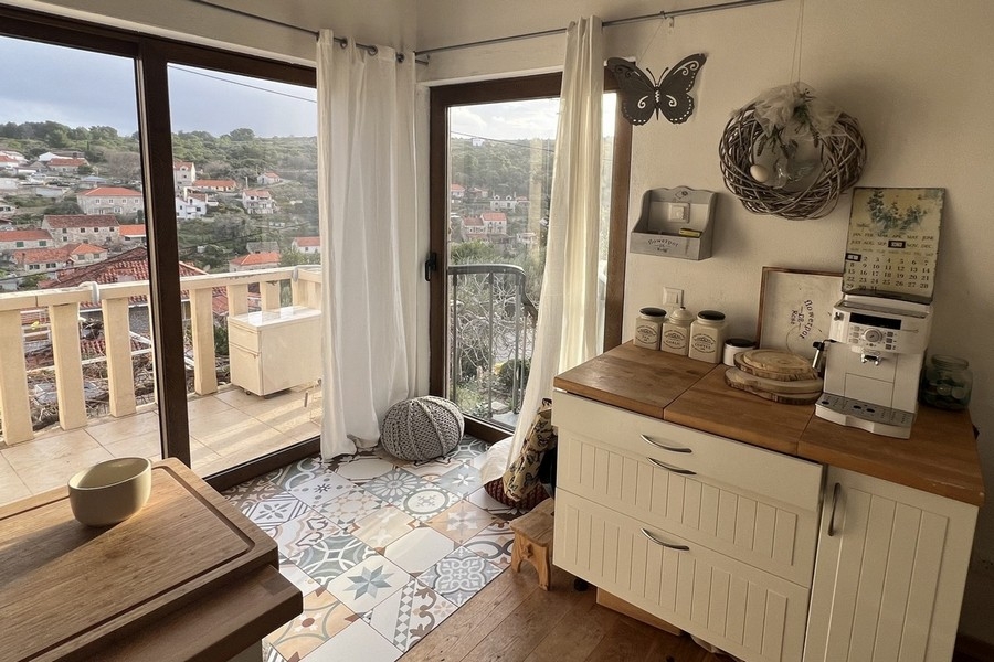 Köksdel med fönster från golv till tak och utgång till balkong