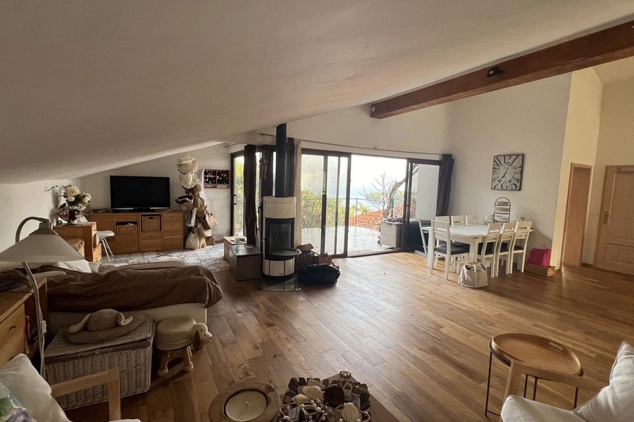 Öppet vardagsrum och matplats med öppen spis och panoramafönster