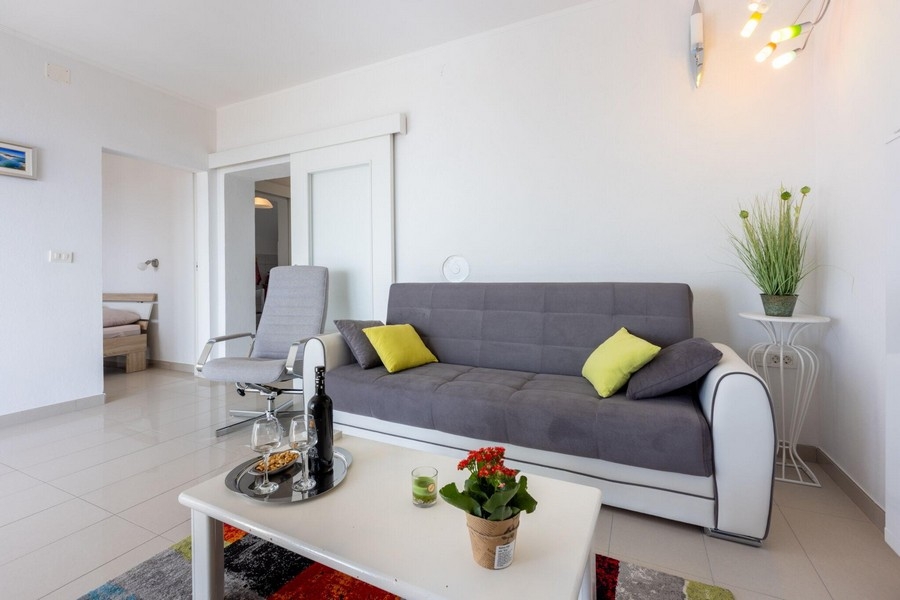 Vardagsrum med soffa och öppen tillgång till sovrummet