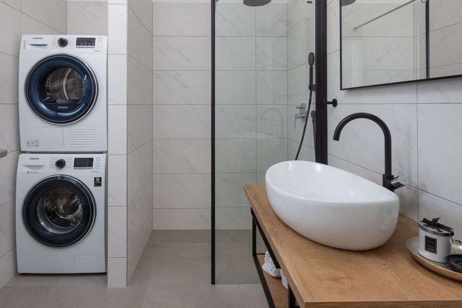 Modernt badrum med dusch och tvättmaskin