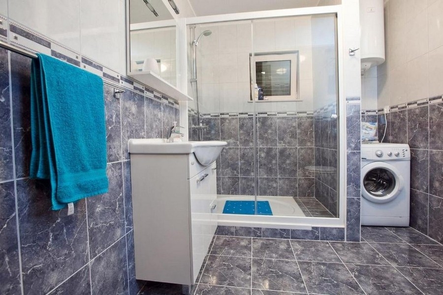 Badrum med dusch och tvättmaskin