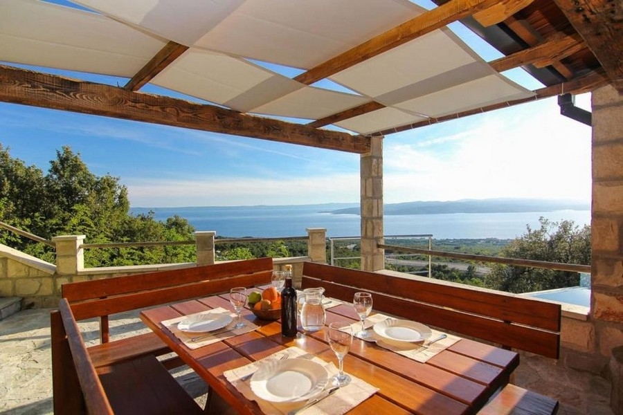 Täckt terrass med sittgrupp och havsutsikt