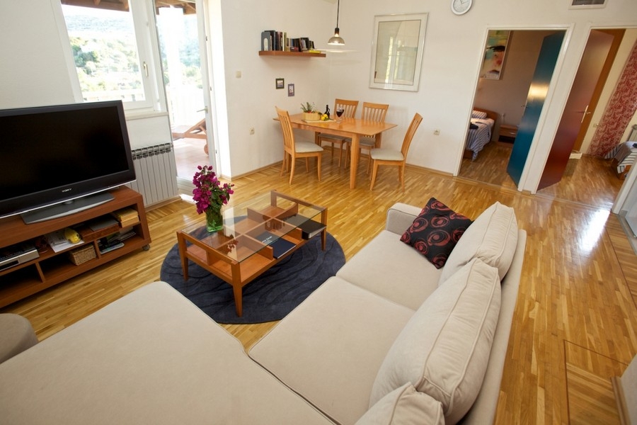 Vardagsrum med soffa, trägolv och matplats