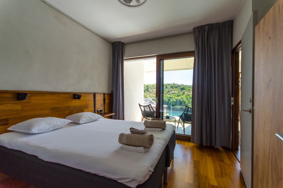 Sovrum med balkong och utsikt över grönskan