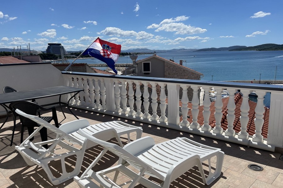 Terrass med solstolar och havsutsikt i Kroatien