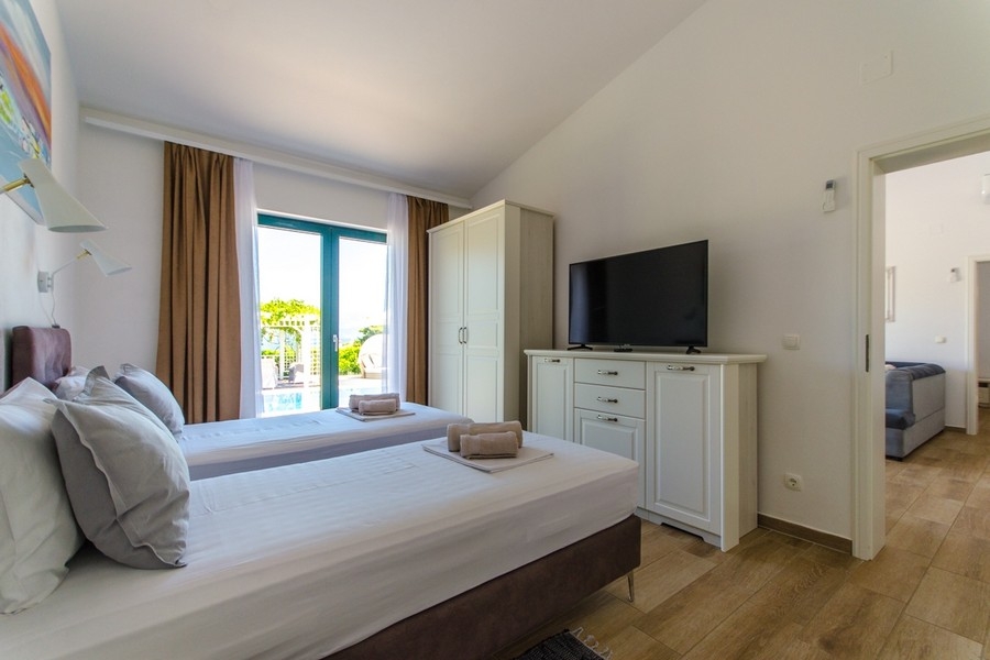 Sovrum med två enkelsängar och utsikt över terrassen