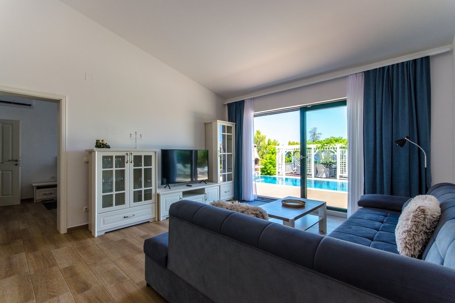 Vardagsrum med utsikt över terrassen och poolområdet