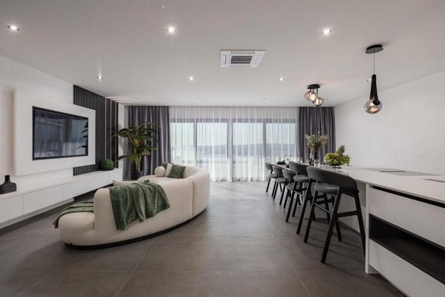 Öppet vardagsrum med kök och stort fönsterfront