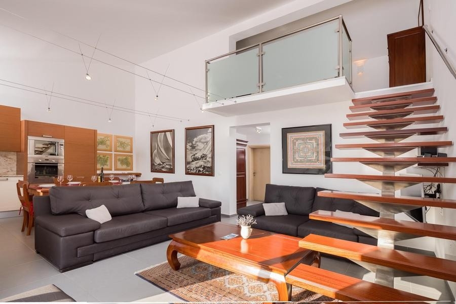 Öppet vardagsrum med kök och galleri