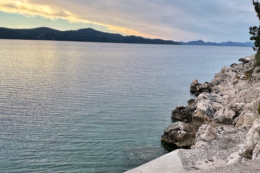 Klippiga kusten och kristallklart hav framför fastigheten