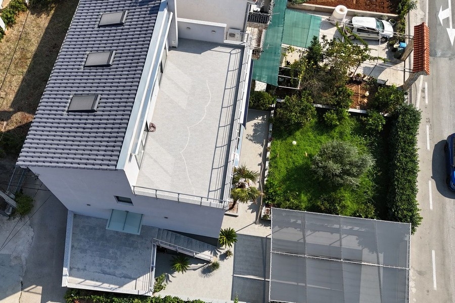 Flygfoto hus med trädgård och parkeringsplatser nära havet i Marina