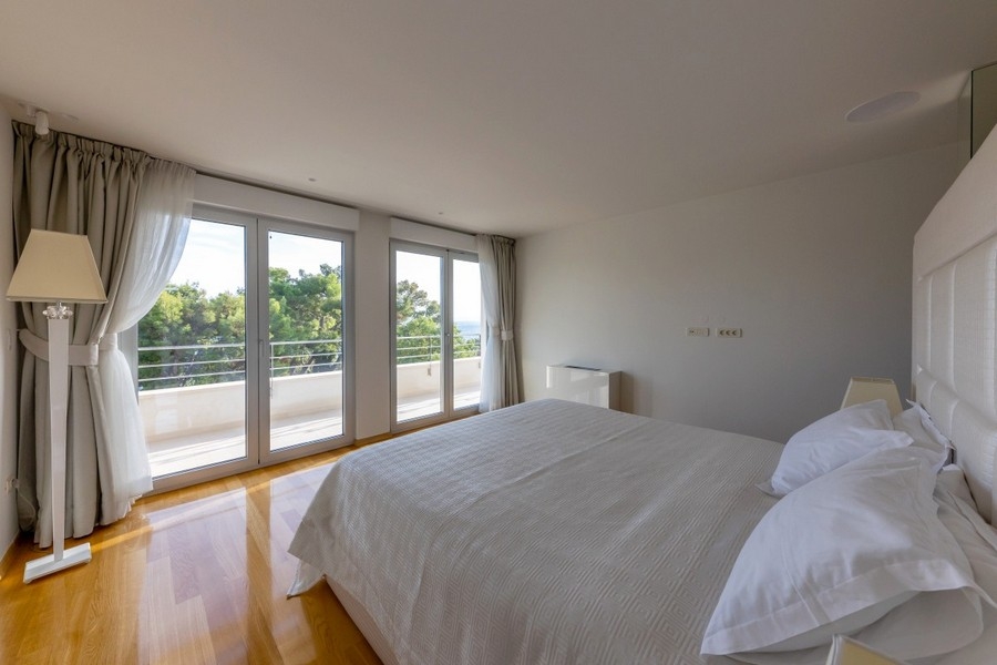 Sovrum med balkong och utsikt över grönskan