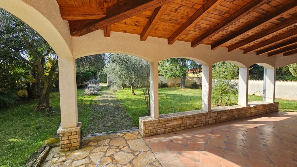 Täckt terrass med sittgrupp och utsikt över trädgården