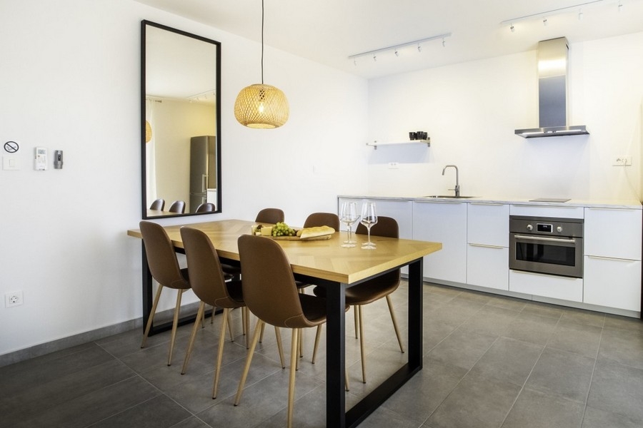 Öppet kök med matbord och modernt utrustat kök