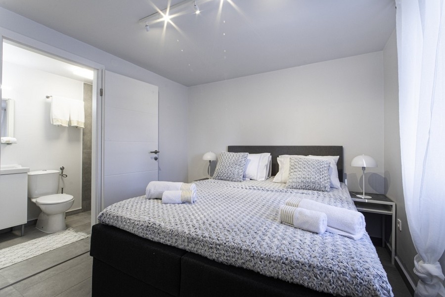 Sovrum med dubbelsäng och badrum med eget badrum