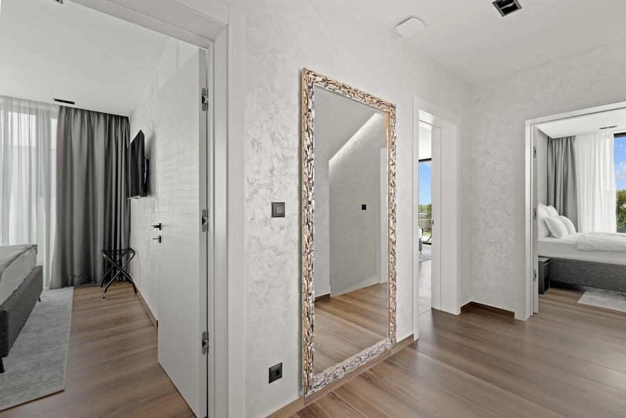 Sovrum med stort fönster och utsikt över grönskan